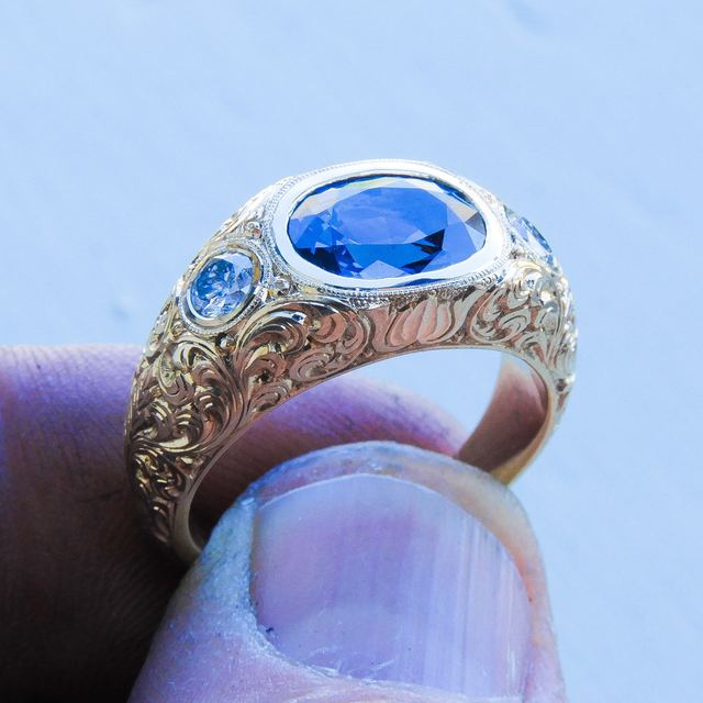 Wedding band with a sapphire centre stone and hand-engraved scrollwork